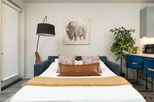 una camera da letto con un letto con lenzuola e cuscini bianchi di Queen Downtown Views Riverfront Stay Free Parking a Fort Worth Altre 27 foto