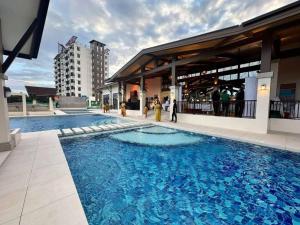 a large blue swimming pool next to a building at Driftwood Nook in Dauis