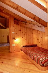 a bed in a room with wooden walls at Balcone sulle Tre Cime di Lavaredo in Misurina