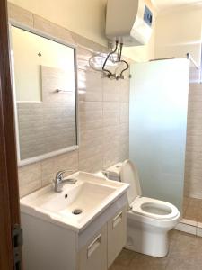 ein Badezimmer mit Waschbecken, Toilette und Spiegel in der Unterkunft Verdant Treehouse in Kigali