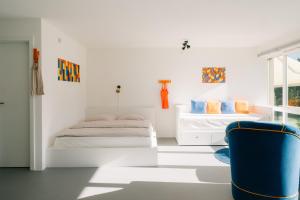 a bedroom with two beds and a blue chair at Apartment Baytrail in See- und Bergnähe, modern, mit Garten, 4 Gäste in Spiez