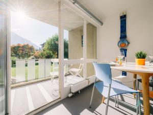a room with a table and chairs and a large window at Apartment Baytrail in Seenähe in Spiez +14 photos