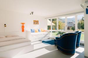 a bedroom with a bed and two blue chairs at Apartment Baytrail in Seenähe in Spiez