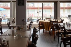 a restaurant with tables and chairs and a large window at Auberge Royal Versailles in Montreal