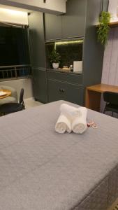 una stanza con un letto con due asciugamani sopra di Dani Studio Moema Grand Vitrali a San Paolo