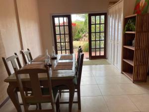 a dining room with a wooden table and chairs at 1 Bed Apt Port Louis Marina view in Blow Hole