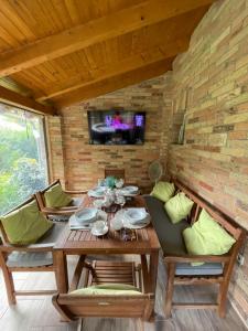 a dining room with a table and chairs and a tv at Rózsa Apartman Dombori in Fadd-Dombori