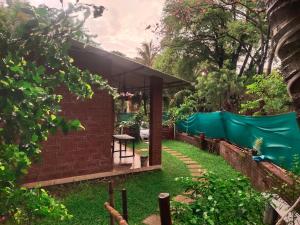 a pavilion in a garden with a green tarp at Shivai holiday home in Alibaug