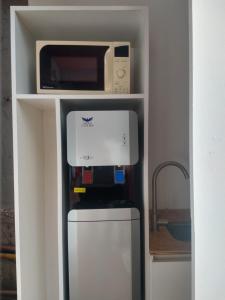 Un horno microondas colocado encima de un refrigerador. en Hostería El Bosque, en Villa Gesell