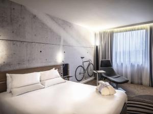 a bedroom with a white bed and a black chair at Novotel Kraków Centrum in Kraków +146 photos