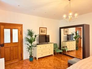1 dormitorio con tocador, TV y espejo en Charme Boutique Old Town, en Brasov