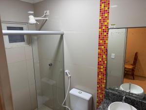 a bathroom with a shower and a toilet and a sink at D'lazer Motel in Caruaru