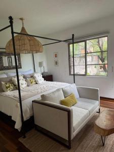 a bedroom with a large bed and a couch at Casa Arroyo in San Miguel de Allende