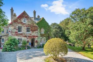 an old stone house with a garden in front of it at The Old Vicarage in Truro