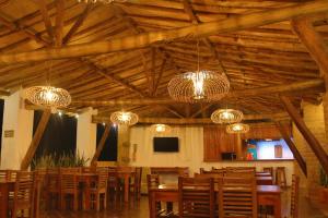 a dining room with chandeliers and tables and chairs at Hotel Victoria Barichara in Barichara