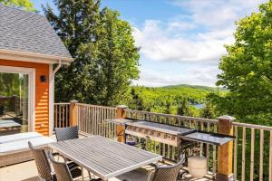 a patio with a table and chairs on a deck at Le Chalet Orange in Shawinigan