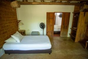 a bedroom with a bed and a room with a fan at Hotel Victoria Barichara in Barichara +35 photos
