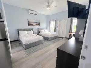 a living room with a bed and a flat screen tv at Town Centre Abaco in Marsh Harbour