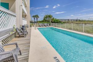a swimming pool with chaise lounge chairs on a deck at Direct Beach Access! Walkable Condo on Ocean Blvd in Myrtle Beach