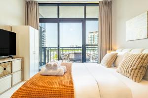 a hotel room with a large bed and a large window at Amazing Rooftop Pool - Full Canal Views - 1 BDR - 5 min walk from Space42 Arena - Heart of Raha Beach in Abu Dhabi