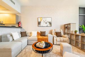 a living room with a couch and a table at Amazing Rooftop Pool - Full Canal Views - 1 BDR - 5 min walk from Space42 Arena - Heart of Raha Beach in Abu Dhabi +41 photos
