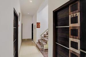 a hallway with a wooden door and a staircase at Super Hotel O Golden Imperial in Noida