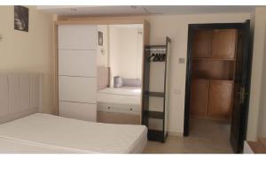 a room with a bedroom with a bed and a closet at Room self catering in Ossett