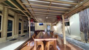 a dining room with a wooden table and chairs at Jenny's Bamboo Surf Camp in Karbang