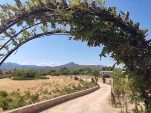 Un arco sobre un camino de tierra en un campo en EuZoea Country Home, en Kapandrítion