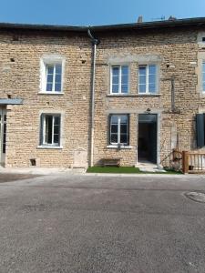 an empty street in front of a brick building at Les Murmures Desbordes in Châteauvillain