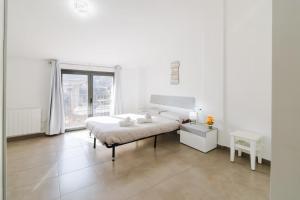 a white bedroom with a bed and a window at La Caseta de Cercs, Barbecue y Pet Friendly in Sant Jordi de Cercs