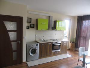 a kitchen with a washing machine and green cabinets at Emona Apartment in Burgas City