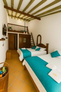 a bedroom with two beds and a loft at Hotel - Hospedería Villa Palva in Villa de Leyva +13 photos