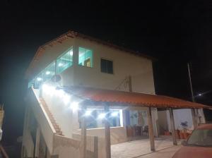 a house with lights on the side of it at night at Pousada Monte Belo in Carrancas