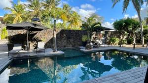 a swimming pool with two chairs and an umbrella at Sablexotique in Pointe d'Esny