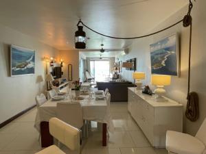a dining room and living room with a table and chairs at Sablexotique in Pointe d'Esny