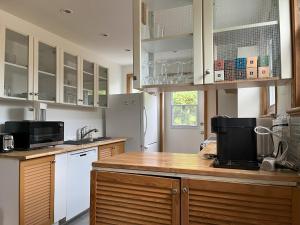 a kitchen with white cabinets and a wooden counter top at Le 886, 3 chambres in Quebec City