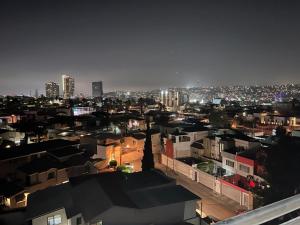 a view of a city at night with buildings at Departamento con 3 habitaciones en Torre Palmas in Tijuana