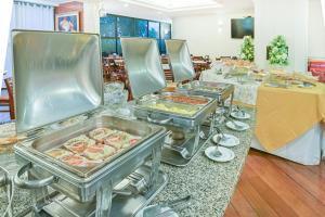 a buffet line with several trays of food at Hotel Dan Inn Campinas Cambuí - Um Hotel Clássico em Campinas By Nacional Inn in Campinas