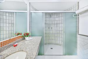 a bathroom with a shower and a sink at Hotel Dan Inn Campinas Cambuí - Um Hotel Clássico em Campinas By Nacional Inn in Campinas +52 photos