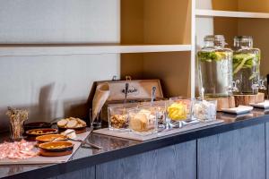a buffet with various food items on a counter at NH Eindhoven Conference Centre Koningshof in Veldhoven