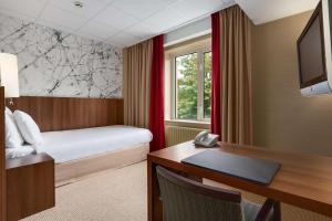 Postel nebo postele na pokoji v ubytování NH Eindhoven Conference Centre Koningshof