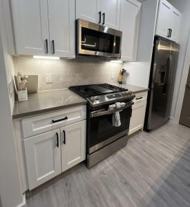 a kitchen with white cabinets and a stove and refrigerator at Spacious 3BR Retreat Pergola and Fire Pit in Houston