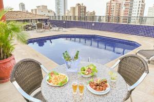 a table with plates of food on top of a patio at Hotel Dan Inn Campinas Cambuí - Um Hotel Clássico em Campinas By Nacional Inn in Campinas