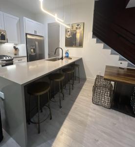 a kitchen with a counter with bar stools and a sink at Spacious 3BR Retreat Pergola and Fire Pit in Houston