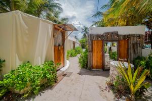 a garden with a wooden gate and some plants at Arena y Mar Seaside Glamping - Adults Only by The Spot Rentals in El Cuyo +42 photos