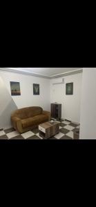 una sala de estar con un sofá y una mesa en Appartement calme et lumineux, en Sousse