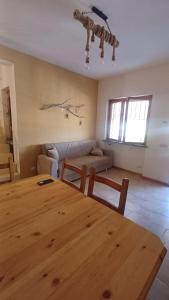 a living room with a wooden table and a couch at Ylenia Summer Beach in LʼAmericano