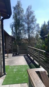 un porche con una valla de madera y césped verde en Appartements indépendants dans chalet en Auvergne, en Chomelix