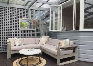 a living room with a couch and a table at Tosca Elegant Merewether Beach House with Pool in Merewether